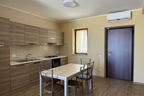 Cozinha moderna com armários de madeira, uma mesa de jantar e cadeiras.