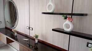 A modern bathroom with a wooden vanity, a large mirror, and two white vases with flowers. - Protels Royal Bay Resort & Spa (Hurghada)