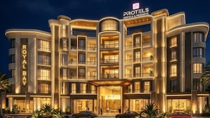 A multi-story hotel with a prominent entrance, balconies, and a sign indicating it is part of the Proteels Hotels & Resorts. - Protels Royal Bay Resort & Spa (Hurghada)
