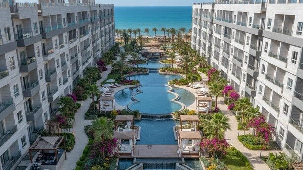 A resort with a central pool, surrounding lounge areas, and a view of the sea. - Protels Royal Bay Resort & Spa (Hurghada)