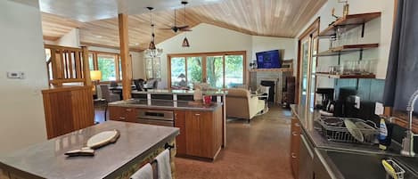 A spacious kitchen with wooden cabinets, a central island, and a dining area with a sofa.