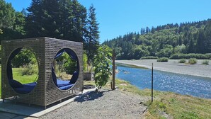 Un belvédère doté d’ouvertures circulaires, offrant une vue sur une rivière et une forêt.