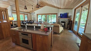 Une cuisine moderne dotée d’un îlot central, de meubles en bois et d’une cheminée.