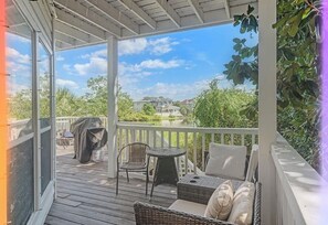 Ein überdachter Außenbereich mit Seeblick, Grill und Gartenmöbeln.