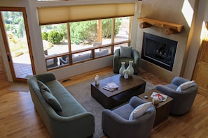 Una sala de estar con sofá, sillones, una mesa de centro y una chimenea.