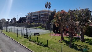 A multi-story hotel with balconies, a tennis court, and a playground. - Sea and Sun (Saint-Laurent-du-Var)