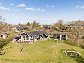 A residential area with houses, a swing set, and a fire pit. - 4 Star Holiday Home in Struer (Struer)