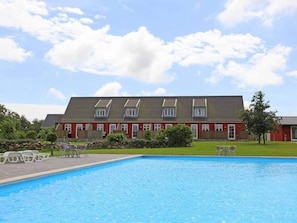 Eine Reihe roter Häuser mit einem Schwimmbecken im Vordergrund.