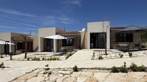A courtyard with stone flooring, outdoor seating, and a clear blue sky. - Sea-view apartment with a pool (Telegrafo)