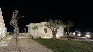 A stone pathway leading to a building with a small garden and palm trees. - Sea-view apartment with a pool (Telegrafo)
