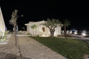 A stone pathway leading to a building with a small garden and palm trees. - Sea-view apartment with a pool (Telegrafo)
