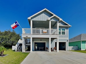 A two-story house with a balcony, a garage, and a flag. - Lone Star Lookout (Rockport)
