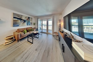 Ein modernes Wohnzimmer mit Sofa, Couchtisch und Blick ins Freie.