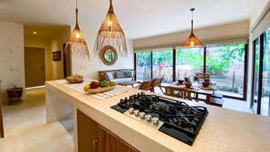 Una cocina moderna con estufa a gas, armarios de madera y luces colgantes.