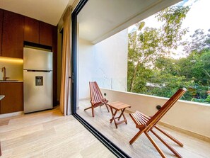 A balcony with wooden chairs and a view of greenery. - 1BR Retreat near Aldea Zama with Pool (Tulum)