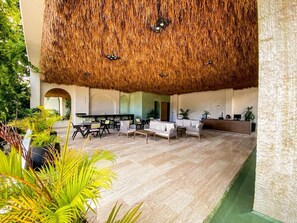 A spacious lobby with a thatched roof, seating areas, and a reception desk. - 1BR Retreat near Aldea Zama with Pool (Tulum)