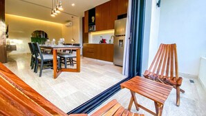 Eine moderne Küche mit Holzschränken, ein Essbereich mit Tisch und Stühlen sowie eine hölzerne Bank.