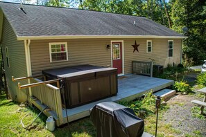 Einbungalow mit überdachter Terrasse, Whirlpool und einem Türschmuck mit Sternen.