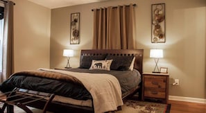 A bedroom with a bed, bedside tables, a headboard, and wall art. - Charming 3-bedroom mountain retreat in beautiful Fort Valley with Hot Tub Hiking (Fort Valley)