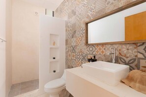 Un bagno moderno con doccia, servizi igienici e lavandino.