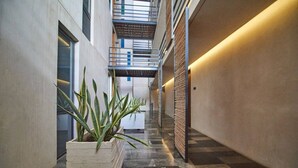 A corridor with a potted plant, a staircase, and a wall with a textured pattern. - Sabor a Miel: Two seaside apartments (Playa del Carmen)