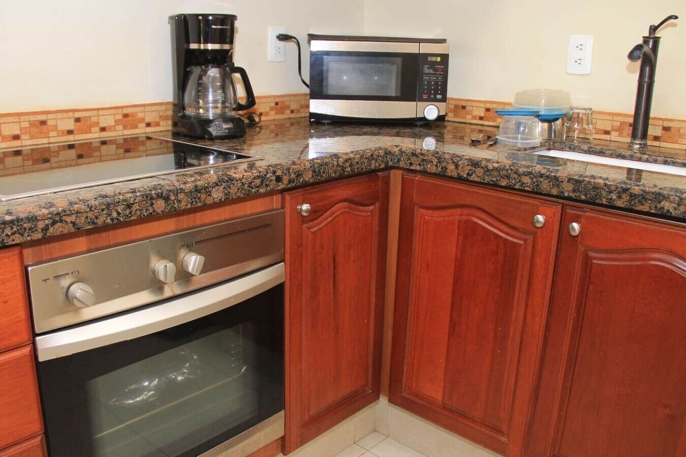 A kitchen with granite countertops, stainless steel appliances, and wooden cabinets.