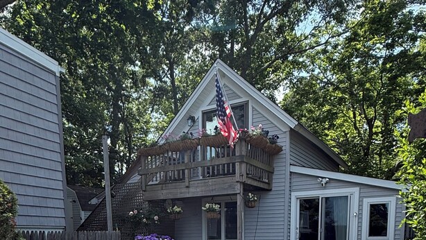 A patio with outdoor furniture, a barbecue grill, and potted plants. - Cozy 2-bedroom waterfront cottage with central AC, patio, BBQ, Private beach (Hampton Bays)