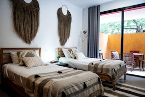 A hotel room with two beds, a small table, a chair, and a balcony with a view. - Lunada: Bright Stay with Rooftop Amenities (Playa del Carmen)