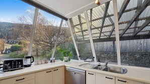 Una cocina con un ventanal grande, un tostador, una cafetera y un lavavajillas.