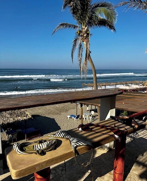Di pantai, kursi berjemur, payung pantai, dan pijat di pantai