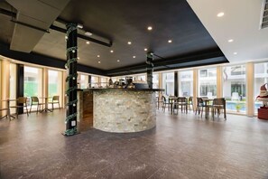 A spacious indoor area with a central stone bar, seating arrangements, and large windows providing natural light. - Stylish Apt with Private Balcony, Pool and Gym (Playa del Carmen)