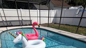 Ein Swimmingpool mit aufblasbaren Einhorn- und Flamingoboots.