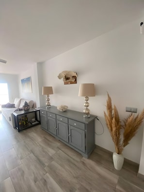 Een woonkamer met een grijze kast, twee lampen, een schedel decoratie en pampa's gras.