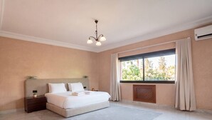 Hotelkamer met groot bed, nachtkastje, raam met gordijnen en een plafondlamp.