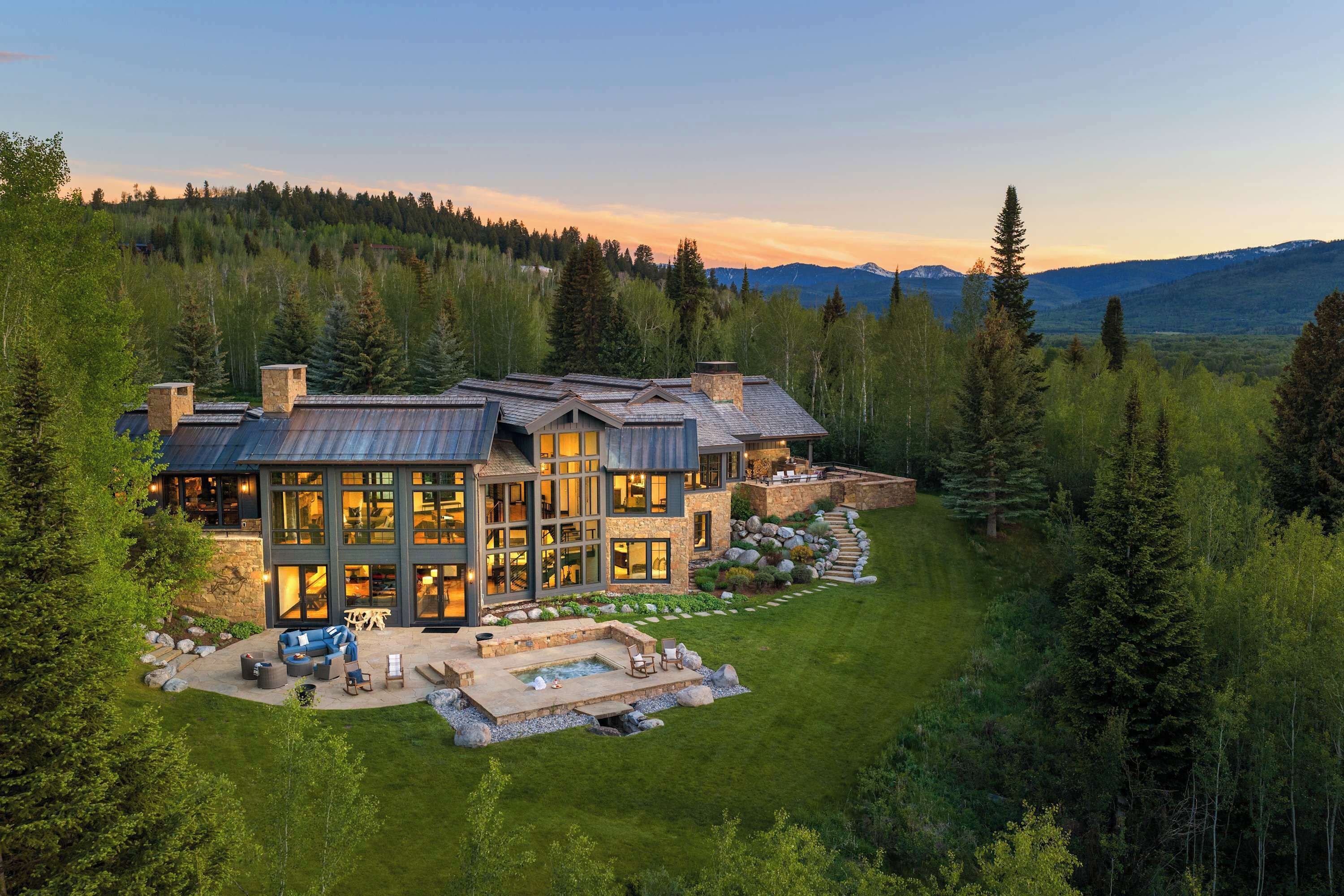 A large, modern house with a spacious patio and a swimming pool.