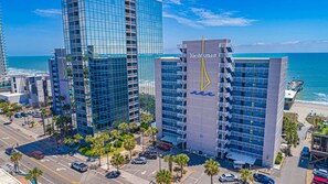 A high-rise hotel with a glass facade, multiple balconies, and a prominent 'Yachtsman' sign.