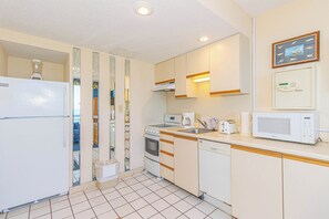 A compact kitchen with a refrigerator, stove, microwave, and sink. - Yachtsman S605 1 BR Oceanfront Retreat (Myrtle Beach)