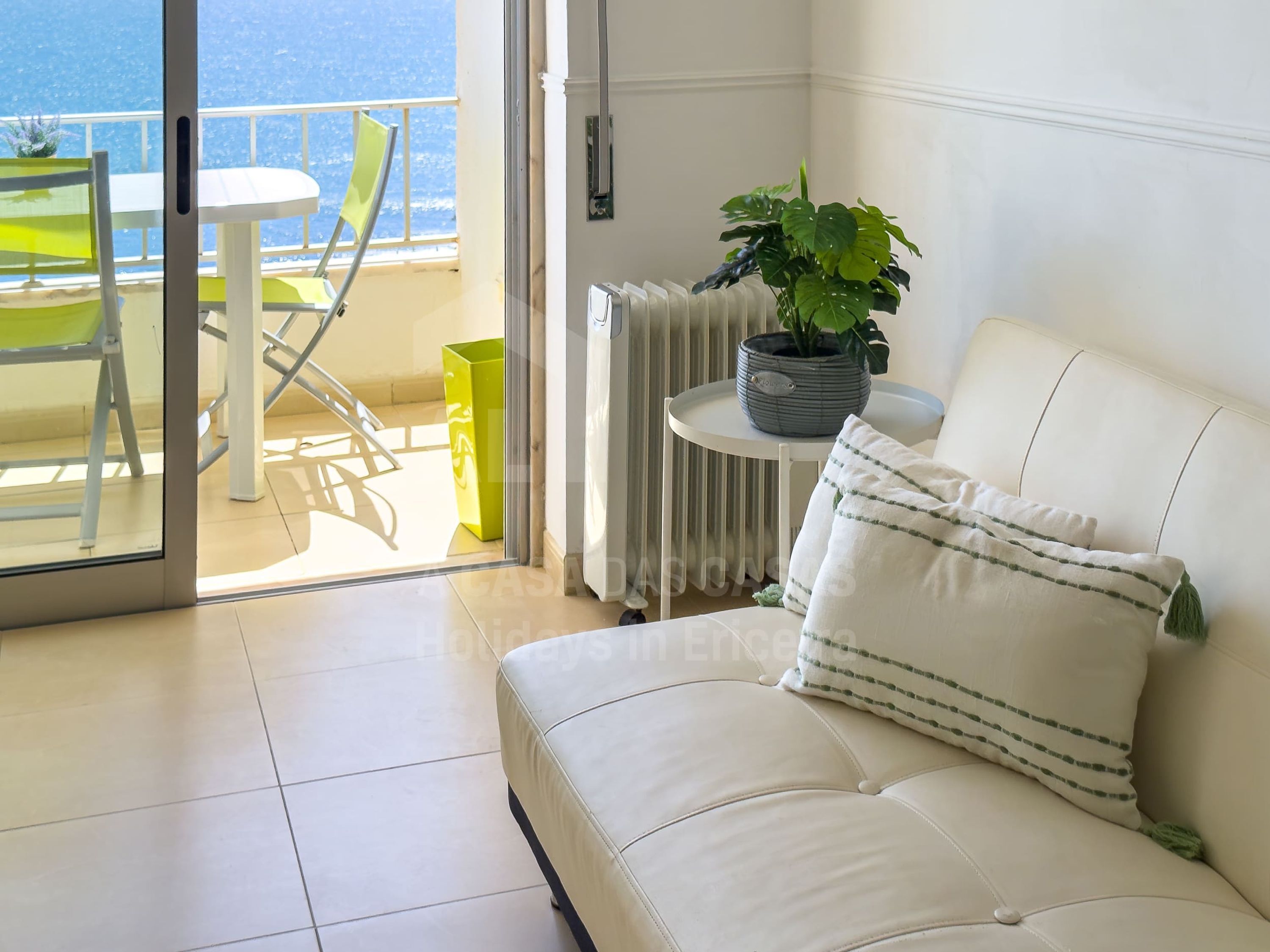 A balcony with a chair, a table, and a potted plant.