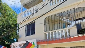 Un immeuble de deux étages, avec une enseigne indiquant « JP Inversión » et un drapeau.