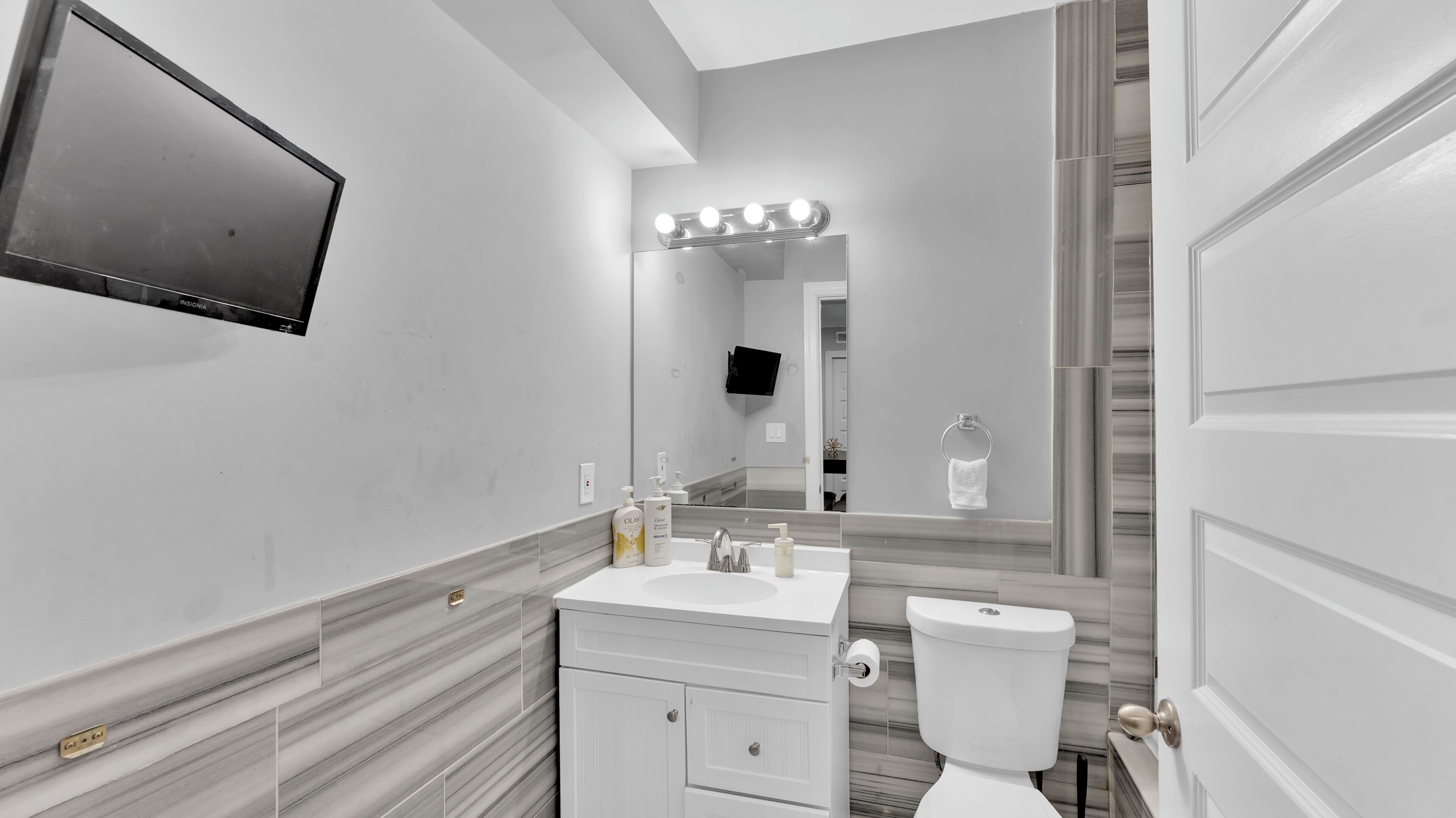 Une salle de bain moderne avec un meuble-lavabo, un évier, un miroir et des toilettes.
