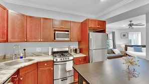 A modern kitchen with wooden cabinets, stainless steel appliances, and a marble countertop. - Apartmint at 1149 N 3rd St Philladelphia (Philadelphia)