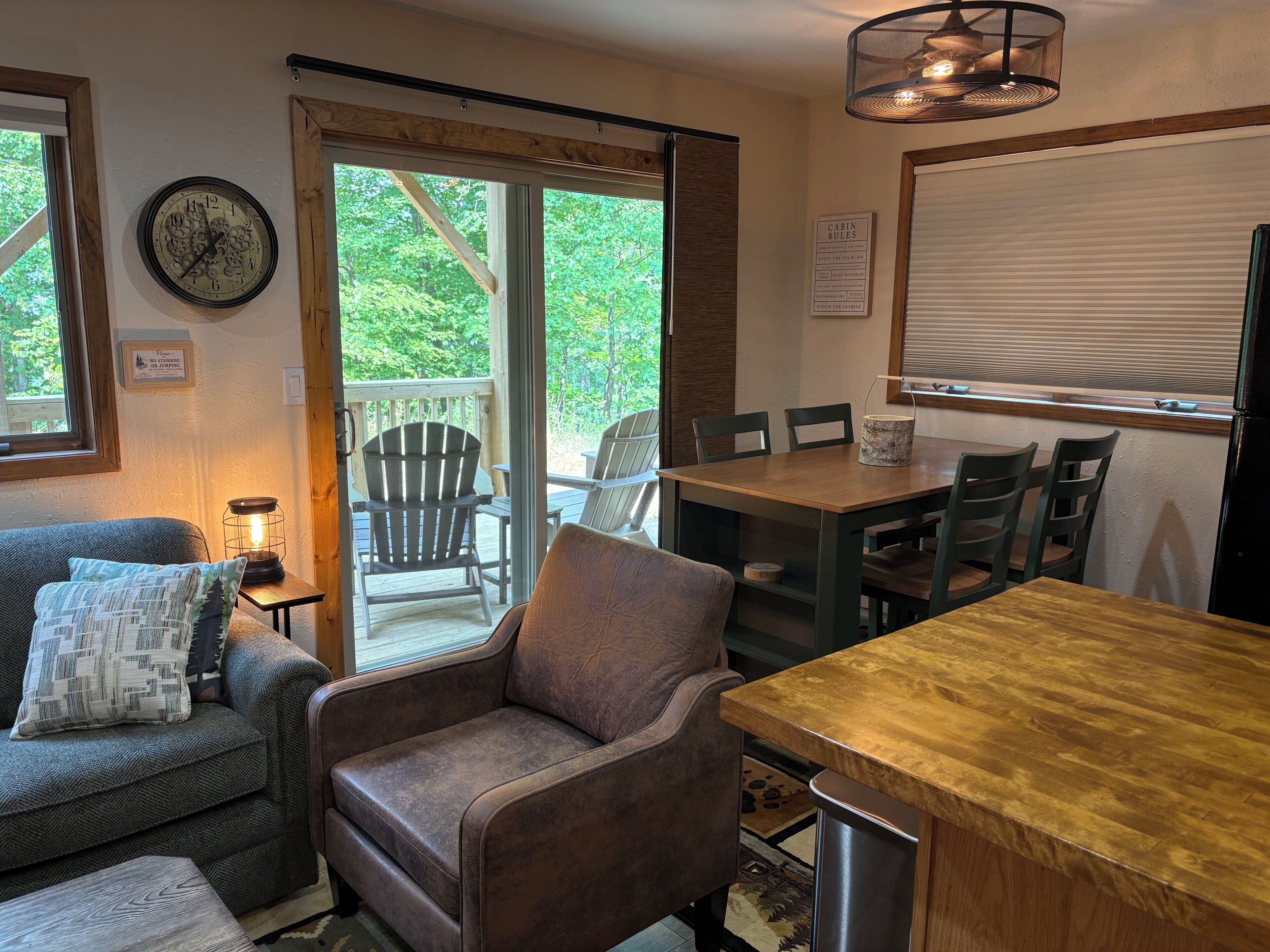 Un intérieur chaleureux avec une table à manger en bois, des chaises, un canapé et une cheminée.
