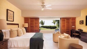 Quarto com cama, escrivaninha, cadeira e vista para o exterior.