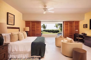 Ein Schlafzimmer mit Bett, Schreibtisch, Stuhl und Blick ins Freie.