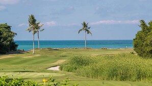 A golf course with a view of the ocean and palm trees. - Luxury Golf-Front Villa: 6BR w/ Private Pool, Chef & Golf Cart (Punta Mita)