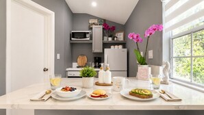 A modern kitchen with a central island, a microwave, a refrigerator, and a window with a view of greenery. - Charm, comfort and an exceptional location ,  Free parking (Miramar)