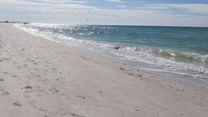 Ein Strand mit Fußabdrücken und Wellen.