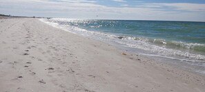 Ein Strand mit Fußabdrücken und Wellen.