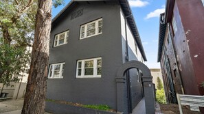 A two-story building with a dark facade, white-framed windows, and a brick entrance. - The 450 Collection Double Bay Stays Suite 3 (Double Bay)