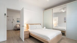 A hotel room with a bed, bedside table, and a large mirror. - The 450 Collection Double Bay Stays Suite 3 (Double Bay)